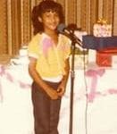 Selena de niña delante de un microfono