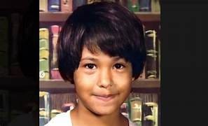 Fotografía de Selena Quintanilla cuando era niña, sonriendo frente a un fondo de libros ,incluida en su biografía