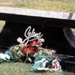 Placa conmemorativa de Selena Quintanilla rodeada de flores dejadas por sus fans, en uno de los lugares de interés dedicados a su memoria
